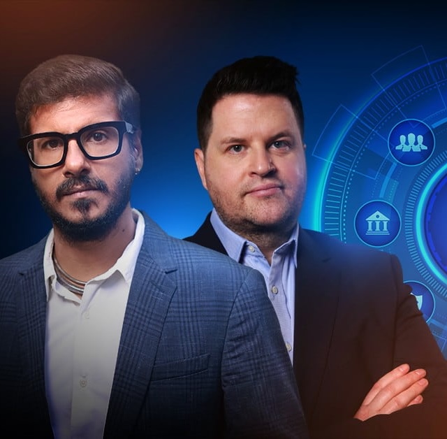 Two men in suits standing side by side against a solid blue background.